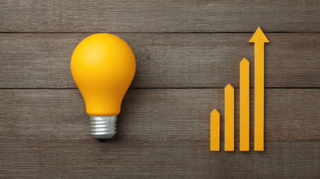 Lightbulb and upward graph icon on wooden background representing new ideas and business goals with copy spaceの素材