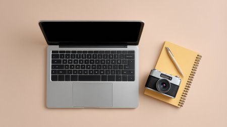 Neutral-colored tabletop workspace with laptop, vintage camera, and planner in flat lay format, space around objectsの素材