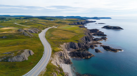 A highway winding along the coast with blue ocean waters and rocky cliffs on one side, offering plenty of space for text.の素材