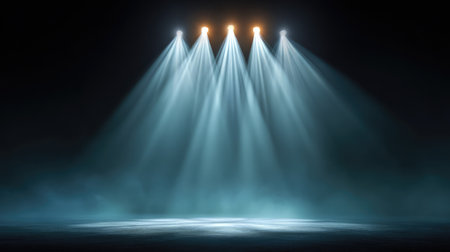 Dramatic stage with bright spotlights shining through haze, creating a theatrical atmosphere with deep shadows and glowing beams, leaving ample copy spaceの素材