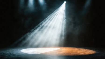 A single beam of club spotlight cutting across an empty dance floor, the surrounding room remaining in complete shadow, with smoke or haze amplifying the intensity of the light. No text, no people.の素材