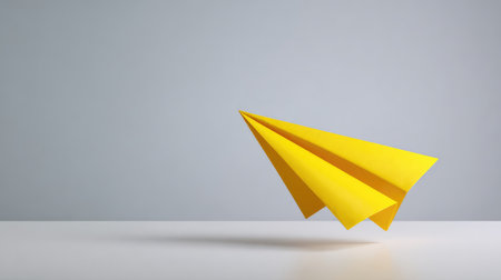 A bright paper plane taking off from a white desk surface, symbol of creative launch or new ideas, with open spaceの素材