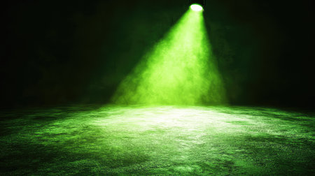 A vibrant green spotlight illuminating a dark stage, casting an ethereal glow over the floor and surrounding space. No text, no people.の素材