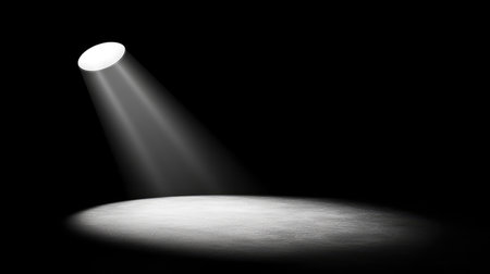 A single club spotlight focused on a darkened floor, casting a perfect beam of light while the rest of the club remains shrouded in darkness, allowing the spotlight to become the main visual focus. No text, no people.の素材