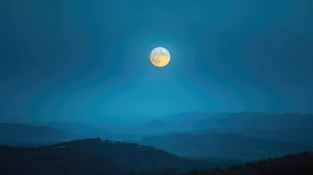 A breathtaking scene featuring a full moon cast over a serene mountain landscape, creating a peaceful ambiance under the clear blue night sky, perfect for nature lovers.の素材
