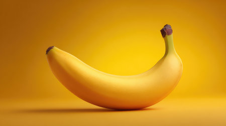 A vibrant single banana stands out against a bright yellow background, symbolizing freshness, nutrition, and healthy eating for various projects and concepts in lifestyle photography.の素材