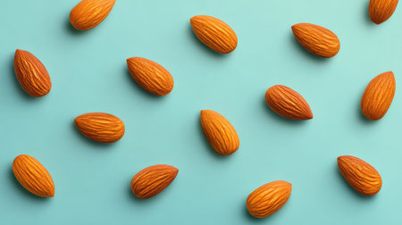 Artistic overhead shot of almonds in neat rows on pastel surface with ample negative spaceの素材