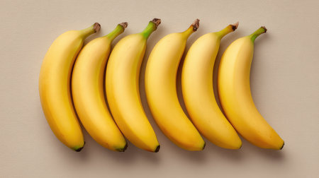 Clean composition of several bananas arranged on neutral paper from top-down perspectiveの素材