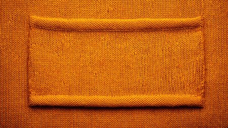 Dark yellow knitted fabric texture with fine detail, overhead view with empty area for text or productの素材