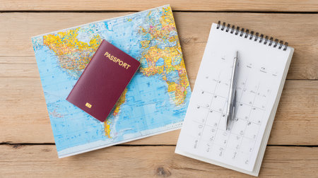 Travel service layout with map, passport, ticket, and calendar on wooden surface, white area left blankの素材