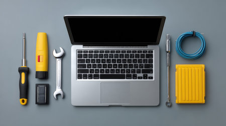 Tech support tools with laptop, screwdriver, cables, and external drives, modern clean surface with spaceの素材