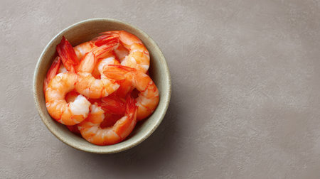 High angle of peeled cooked shrimp in a small bowl placed on textured neutral surface with copy spaceの素材
