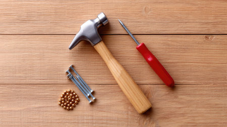 This captivating image showcases essential tools of craftsmanship including a hammer, nails, and a screwdriver arranged on a wooden surface, highlighting the beauty of woodworking.の素材