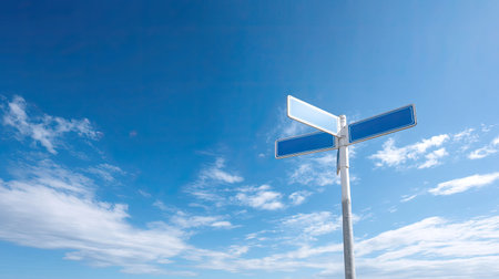 A blank street sign stands tall against a vibrant blue sky filled with fluffy clouds, creating an image of tranquility and open space. Ideal for themes of direction, exploration, and nature.の素材