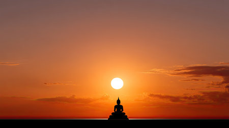 A tranquil silhouette of a Buddha statue against a vivid sunset creates a serene atmosphere, perfect for meditation and reflection amidst nature's beauty.の素材