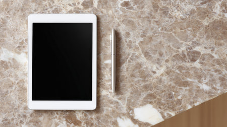 A modern tablet and stylus are elegantly placed on a polished marble surface, presenting a stylish and minimalistic workspace ideal for creative professionals.の素材