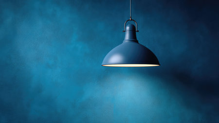 This captivating image features a stylish blue pendant light illuminating a dark blue wall, creating a cozy and modern atmosphere perfect for home decor inspiration.の素材