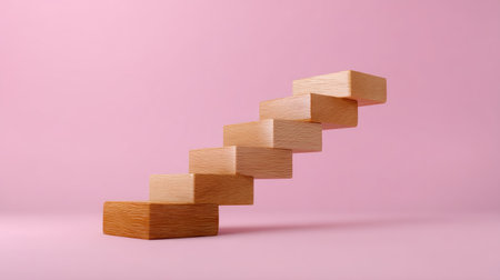 This image depicts a creative arrangement of wooden blocks forming a staircase, symbolizing growth and upward movement against a gentle pink background.の素材