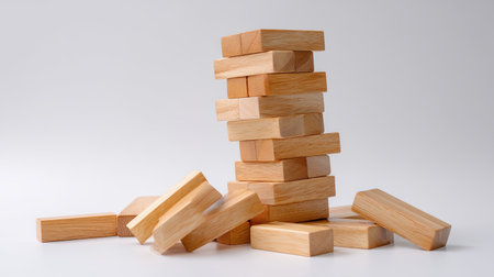 A visually appealing arrangement of wooden blocks stacked with some pieces tilted, representing themes of balance, strategy, and fun in various games and activities.の素材