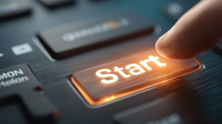 A close-up image showcasing a finger poised to press a glowing start button on a sleek modern keyboard, symbolizing the initiation of technology and digital interaction.の素材