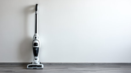 A stylish cordless vacuum cleaner rests unobtrusively against a blank minimalist wall. The image captures the essence of modern home cleaning solutions and efficiency.の素材