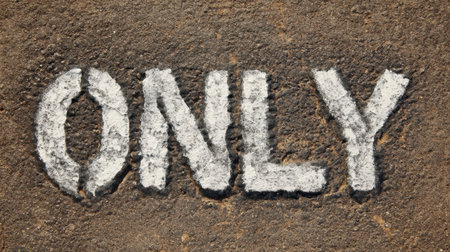 A close-up view of the word 'ONLY' written in chalk on a textured surface, showcasing a minimalistic aesthetic perfect for conveying simple yet powerful messages in creative designs.の素材