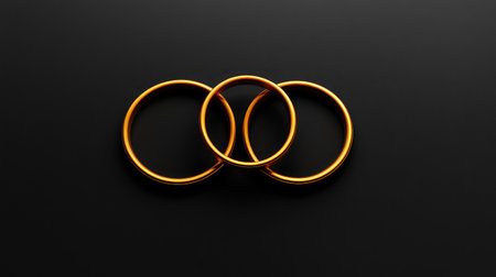 Abstract minimalist golden rings layered over a dark smooth surface. Stylish luxury detail with room for copy.の素材