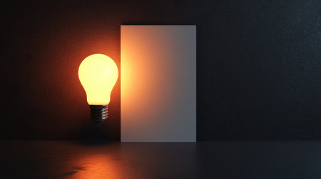 A glowing lightbulb above a blank sheet of paper, symbolizing a bright business idea, with space for text or brandingの素材