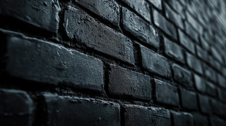 Detailed close-up of a dark textured brick wall showcasing unique patterns and rough surfaces, ideal for use in artistic and design projects with a minimalist aesthetic.の素材