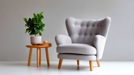 A cozy grey armchair paired with a wooden side table and a small indoor plant creates a stylish and inviting minimalistic interior setting.の素材