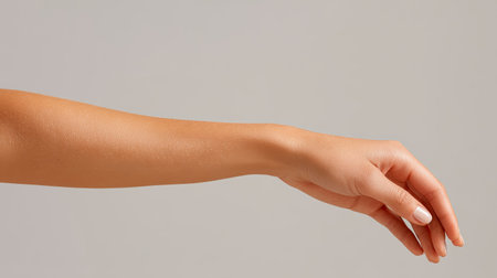 This image features a graceful female hand with a smooth skin tone, elegantly positioned against a soft neutral background, perfect for beauty themes.の素材