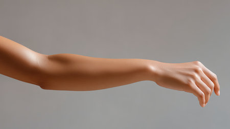 This striking image showcases a realistic human arm and hand in a natural position, highlighting the beauty of skin tone and textures against a plain backdrop.の素材