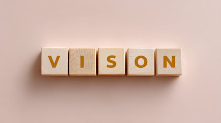 This image features wooden blocks spelling out the word "vision" against a soft pastel background, representing creativity and abstract ideas.の素材