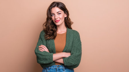 A stylish young woman exudes confidence in a cozy cardigan and warm-toned top. Her relaxed pose and bright smile create an inviting atmosphere, perfect for fashion and lifestyle themes.の素材