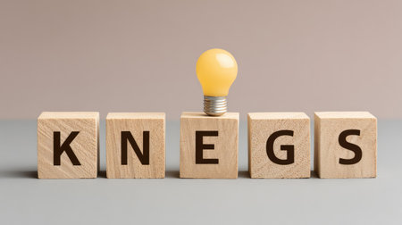 A wooden block arrangement features the word "Knegs" with a light bulb, symbolizing creativity and innovation in a modern setting, perfect for business and educational themes.の素材