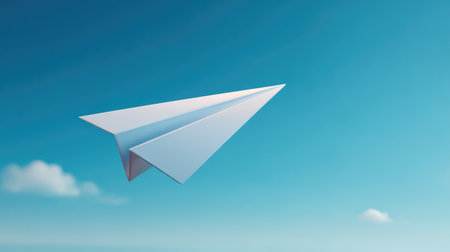 A minimalist image of a white paper airplane gliding gracefully in a bright blue sky, emphasizing themes of adventure, imagination, and the joy of flight.の素材