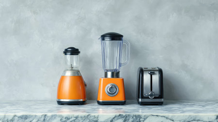 A vibrant collection of kitchen appliances featuring an orange blender, orange toaster, and a modern design. Set against a textured gray backdrop and marble surface.の素材