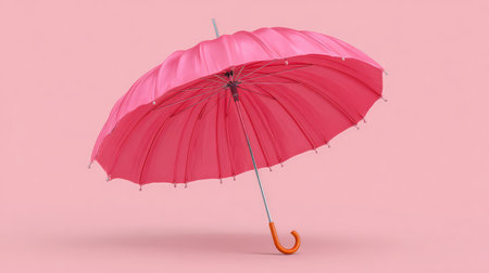 A charming pink umbrella stands out against a soft pink background, embodying playful elegance and perfect for seasonal themes and fashion-related visuals.の素材