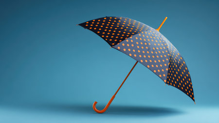A vibrant polka dot umbrella with an orange handle set against a striking blue background, perfect for depicting style, color, and personality in rainy weather scenarios.の素材