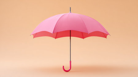 A striking pink umbrella stands alone against a soft peach background, making it a perfect element for colorful designs, fashion themes, and playful imagery.の素材