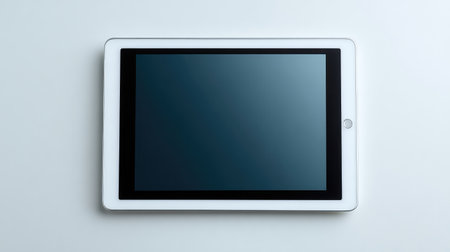 A sleek white tablet with a dark screen rests on a clean surface, perfect for showcasing digital technology themes in modern and minimalistic presentations.の素材
