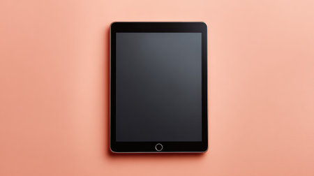 A modern tablet device rests on a chic peach background, featuring a blank screen perfect for showcasing apps or digital designs in creative projects and marketing materials.の素材