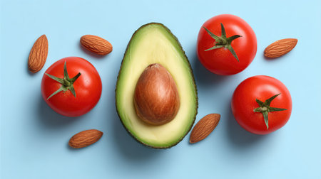 This vibrant composition features a halved avocado with a seed, accompanied by fresh red tomatoes and almonds, perfect for promoting healthful eating and nutrition.の素材