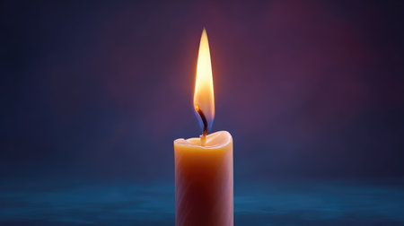 A beautiful close-up of a single candle flame illuminating its surroundings, perfect for conveying themes of peace, relaxation, and cozy ambiance in various settings.の素材