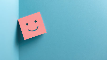 A vibrant sticky note featuring a cheerful smile face on a blue background, perfect for adding positivity and inspiration to any workspace setting.の素材