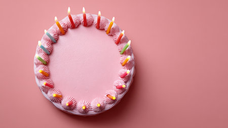 Delight in this beautiful round pink birthday cake adorned with colorful frosting and lit candles, ideal for parties and joyful celebrations, embracing the spirit of happiness.の素材