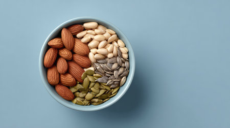 A beautifully arranged bowl of various nuts and seeds, including almonds, sunflower seeds, and pumpkin seeds, perfect for a healthy snack or culinary inspiration.の素材