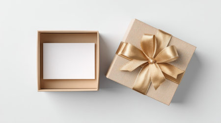 This image features an elegant gift box adorned with a golden ribbon and an empty card, ideal for special occasions and personal messages.の素材