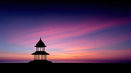 A captivating silhouette of a pavilion stands against a stunning sunset sky filled with vibrant hues of pink and purple, creating a tranquil atmosphere.の素材