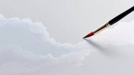 This image showcases an artist's brush delicately applying soft blue textures on a white canvas, revealing the beauty of creativity in a serene environment.の素材